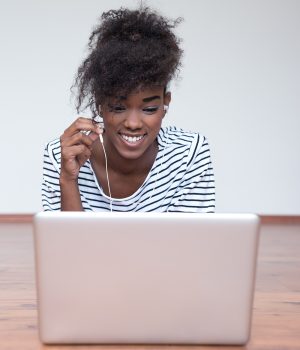 Close up portrait of a smiling young attractive woman relaxing with laptop